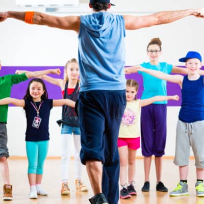 Dance teacher giving kids fitness class